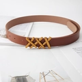 Detail of slim brown leather belt with a golden triple-X cross metal buckle over a magazine - 105cm / Camel
