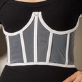 Detailed close-up of a white boned corset belt with grey sheer mesh over a black dress - White