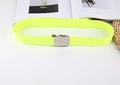 Close-up of neon yellow woven canvas belt with a silver automatic metal buckle on a desk - Neon Yellow
