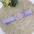 Elastic purple woven belt with amber resin square buckle on a straw mat background - Purple
