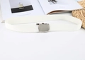 Detailed close-up of a white woven canvas belt with a polished silver metal buckle on a prop - White