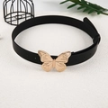 Detail eines schwarzen Vintage-Ledergürtels mit polierter goldener Schmetterlingsschnalle - Schwarz (Goldener Schmetterling)