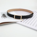Women's black leather belt with gold rectangular buckle shown on a fashion magazine background - Black