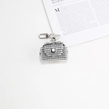 Vue macro d'un mini bijou de sac argenté serti de strass sur un magazine blanc épuré - Mini Sac en Strass Seul (Sans Ceinture) / Argenté