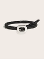 Détail de la texture tressée complexe d'une ceinture noire avec une boucle argentée polie - Noir