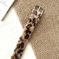 Detail shot of plush leopard print belt with a silver metal buckle on a woven mat - Leopard Plush Belt (1687) / Khaki