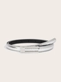 Close-up of a slim silver belt featuring an embossed crocodile texture and a metal buckle - Crocodile Pattern Silver