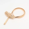 Detail of golden metal leaf buckle and elastic spring belt texture on a white background - Gold (19067)
