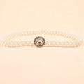 Dettaglio della cintura di perle intrecciate con fibbia a fiore in metallo e strass lucidi - Stile Fiore (19176)