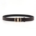 Détail d'une ceinture en cuir café foncé avec une élégante boucle dorée à double anneau ovale - Marron