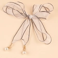 Detalle de cinturón de organza con encaje, colgantes de perlas y costuras elegantes - Estilo de Cinta Blanca