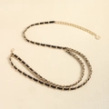 Elegante cintura a catena in metallo dorato con pelle intrecciata e ciondolo a moneta - Oro