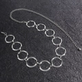 Detailed close-up of polished silver metal waist chain with geometric circular rings - S / Silver