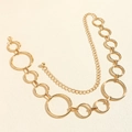 Dettaglio macro della cintura a catena dorata minimalista con maglie circolari - Oro