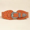 Dettaglio della fibbia vintage incisa in argento su cintura elastica marrone arancio - Cammello