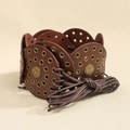Detail of vintage sunburst metal medallions on a brown braided boho waist belt - Bronze Red Brown