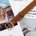 Ceinture marron avec boucle carrée argentée et coutures blanches sur fond vintage - Camel