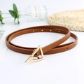 Brown slim leather belt with triangle gold buckle on white table with green plants deco - Camel
