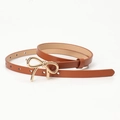 Elegante bruine smalle damesriem met een modieuze gouden metalen strik gesp versiering - camel