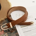 Cintura chic in pelle cammello con fibbia dorata e punta in metallo su sfondo lifestyle - Cammello