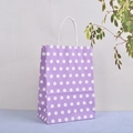 Détail du sac cadeau en papier kraft à pois violets avec poignées en papier blanc - Violet