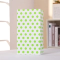 Gros plan détaillé d'un sac cadeau en papier à pois verts et blancs sur une table - 24x13x8 / Vert à Pois