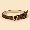 Dettaglio della cintura zebrata da donna con elegante fibbia in metallo dorato a forma di V - 102 Tipo / Zebra Print