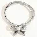 Dettaglio cintura elastica in metallo argento con fibbia a fiocco e perla centrale - Taglia unica / Argento