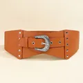 Dettaglio di un'ampia cintura in pelle PU marrone con fibbia argentata goffrata vintage - Cammello