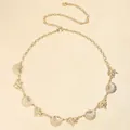 Detail of bohemian gold waist chain featuring metallic seashells and conch ornaments - Gold