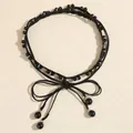 Detail der eleganten schwarzen Taillenkette mit Perlen, Kristallakzenten und Schleife - Schwarz