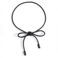 Dettaglio di una cintura a corda nera minimalista con eleganti terminali cilindrici decorativi - Nero