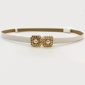 Dettaglio di cintura vintage in pelle bianca con fibbia quadrata dorata e perla - Bianco