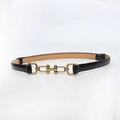 Dettaglio della fibbia a morsetto in ottone vintage su una sottile cintura nera da donna - Nero