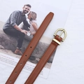 Detail of slim brown PU leather belt featuring a golden horseshoe buckle and fine stitching - Camel