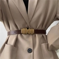Fashionable dark brown leather belt with elegant golden buckle on a khaki blazer - Coffee