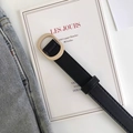 Close-up of a minimalist black leather belt with an oval golden buckle on denim jeans - Black