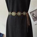 Detail der Vintage-Boho-Taillenkette mit türkisfarbenen Blumen auf schwarzem Kleid - Reisperle Gold