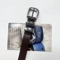 Close-up of deep brown leather belt with polished silver pin buckle and dual metal loops - Coffee
