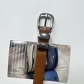 Detail of brown leather belt featuring a polished silver horseshoe buckle and metal loops - Brown