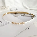 Close-up of thin white leather belt with gold metal buckle and elegant pearl details - White Glossy