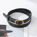 Detail view of black PU leather belt with vintage gold buckle and neat stitching on edges - Black
