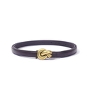 Detailed macro view of the elegant golden knot metal buckle on a slim PU leather belt - Coffee
