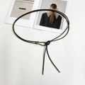 Detail of thin brown knotted belt with silver metal slide buckle and elegant cylinder tips - Coffee