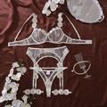 Detail van witte doorschijnende lingerie met madeliefjesborduurwerk en maatlabel S - S / Wit