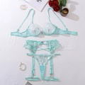 Détail de broderie florale vert menthe et nœuds sur l'ensemble de lingerie trois pièces en dentelle - S