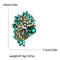 Vintage gold alloy brooch with emerald green crystals, measuring 9.8cm by 7.2cm - Green