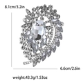 Retro crystal brooch with large oval rhinestone and scrolls, 8.1cm by 6.6cm dimensions - Silver