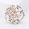 Elegant gold flower brooch with white crystal rhinestones on minimalist pedestal - Gold