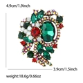 Macro view of vintage alloy floral brooch with deep green crystal and colorful rhinestones - Green